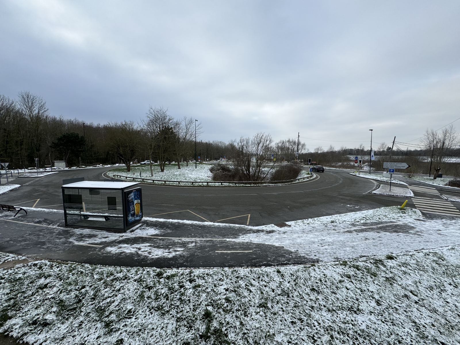 A snow-covered roundabout and lone bus shelter on the Saclay plateau