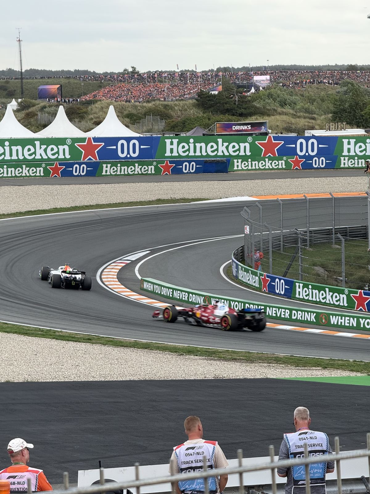 Two Formula 1 cars sweeping through a banked corner at Circuit Zandvoort